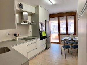 a kitchen with white cabinets and a table with a dining room at Apartamento Oteixon in Narvarte