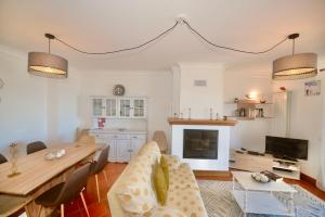 a living room with a table and a dining room at 'Collasão' - Stunning Duplex with Pool & Sea Views in São Martinho do Porto