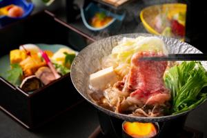 a bowl of food on a table with chopsticks at The Prince Park Tower Tokyo - Preferred Hotels & Resorts, LVX Collection in Tokyo