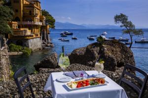 a table with a plate of food and a glass at Hotel Piccolo Portofino in Portofino