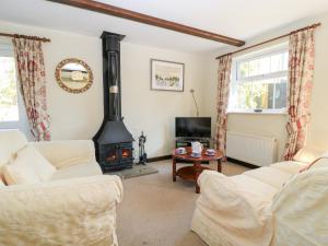 a living room with a wood stove at Grist Mill Cottage in Fontmell Magna