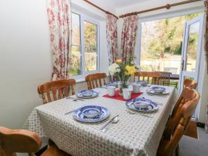 a dining room table with blue and white dishes on it at Grist Mill Cottage in Fontmell Magna