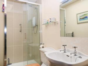 a bathroom with a sink and a shower at Grist Mill Cottage in Fontmell Magna +17 photos