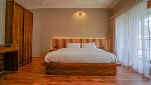 a bedroom with a bed and a large window at Richi A Boutique House in Leh