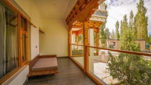 a balcony with a bench and a large window at Richi A Boutique House in Leh