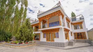 a large white house with trees in front of it at Richi A Boutique House in Leh