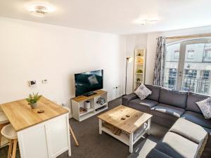 ein Wohnzimmer mit Sofa und Tisch in der Unterkunft Luxury 2BR W Balcony Cathedral Qtr Parking! - Pass the Keys in Belfast
