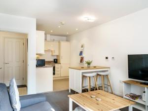 ein Wohnzimmer mit Tisch und Küche in der Unterkunft Luxury 2BR W Balcony Cathedral Qtr Parking! - Pass the Keys in Belfast