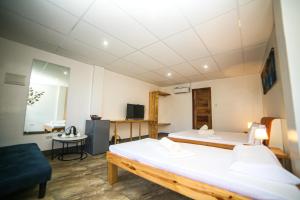 a room with two beds and a tv in it at Buona Resort in Panglao