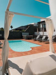 basen z leżakami i parasolem w obiekcie Lanzarote Villa Ascanio w mieście Playa Blanca