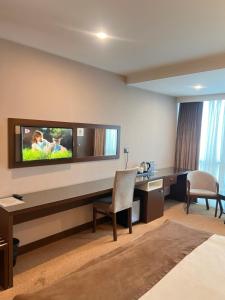 a hotel room with a desk and a tv on the wall at Hotel Diamond in Baku