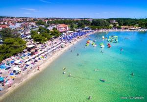 an aerial view of a beach with people in the water at Villa Green s bazenom in Medulin