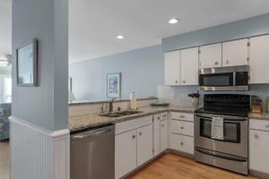 a kitchen with white cabinets and stainless steel appliances at Breakers C32 condo in Pine Knoll Shores