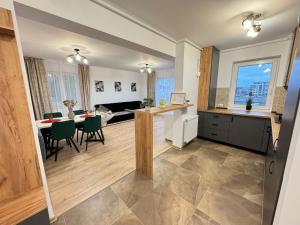 a kitchen and living room with a table and a dining room at Coresi Area Luxury GAP Apartments in Braşov +33 photos