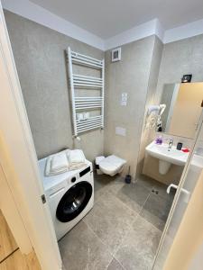 a bathroom with a washing machine and a sink at Coresi Area Luxury GAP Apartments in Braşov