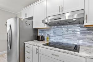 a kitchen with white cabinets and a stainless steel refrigerator at The Gray Whale Cottage home in Beaufort