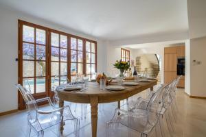 ein Esszimmer mit einem großen Holztisch und Stühlen in der Unterkunft Exceptionnel - Couvent entièrement rénové - classé Patrimoine - Piscine, au calme et à 100 m du coeur de l'Isle in LʼIsle-sur-la-Sorgue