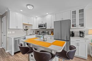 a kitchen with white cabinets and a table and chairs at Southwinds G10 Ocean View condo in Atlantic Beach +22 photos