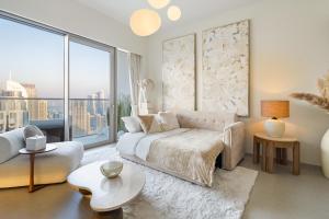 a living room with a couch and a large window at Bella Elite Homes at Grande Signature Full Burj Khalifa and Foutain View - Brand New Luxury Apartment in Dubai