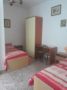 a bedroom with two beds and a desk and a table at Antichi Sapori da Speranza in Gavoi