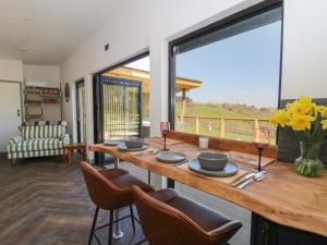 a dining room with a table with chairs and a large window at Llety Cariad in Llandrindod Wells