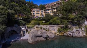 a building on a hill next to a body of water at Hotel Piccolo Portofino in Portofino
