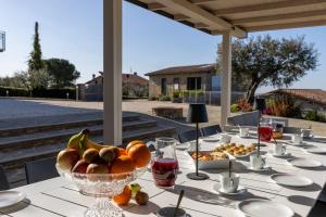 una mesa con un bol de fruta en ella en Villa Acquaviva with Panoramic, Private Pool and Gym - by PosarelliVillas, en Panicale