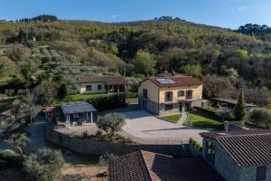 una vista aérea de una casa con una montaña en Villa Acquaviva with Panoramic, Private Pool and Gym - by PosarelliVillas, en Panicale