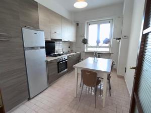 ポテンツァにあるCh Suite - Apartment - Piazza Prefetturaのキッチン(白い冷蔵庫、テーブル、椅子付)