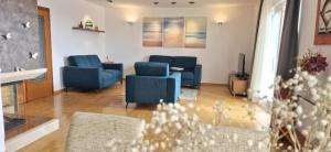 a living room with two blue chairs and a table at SEA VIEW- spacious apartment with shared pool in Split