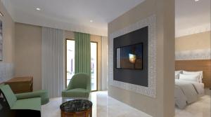 a bedroom with a bed and a tv on a wall at Kenzi Azghor in Ouarzazate +10 photos