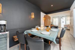 Un comedor con una mesa y sillas azules. en Maison de vacances, en Groix