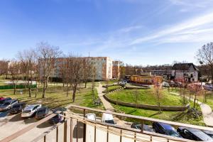 a parking lot with cars parked in front of a building at Wejhera Beige Chic Apartment by BookingHost in Gdańsk