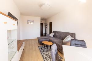 a living room with a couch and a table at Wejhera Beige Chic Apartment by BookingHost in Gdańsk
