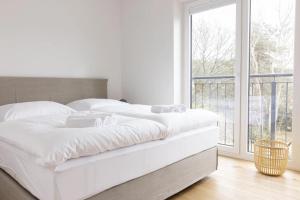 a white bed in a room with a window at Steuerbord in Sankt Peter-Ording