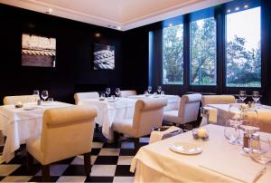 a restaurant with white tables and chairs and windows at Hotel Piccolo Portofino in Portofino