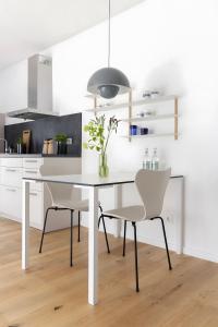 a white kitchen with a white table and chairs at Steuerbord in Sankt Peter-Ording +20 photos