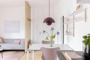 a white living room with a table and a couch at Kajüte in Sankt Peter-Ording