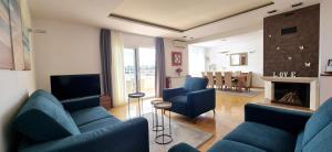 a living room with blue couches and a fireplace at SEA VIEW- spacious apartment with shared pool in Split
