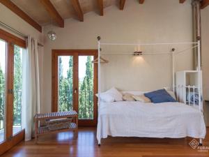 a bedroom with a white bed and a window at Son Senyor in Sa Pobla