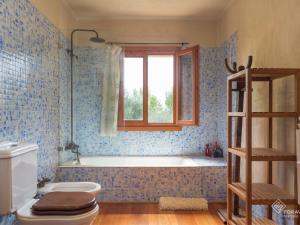 a bathroom with a tub and a toilet and a window at Son Senyor in Sa Pobla +29 photos