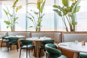 a restaurant with round tables and green chairs at The Social Hub Rome in Rome +18 photos