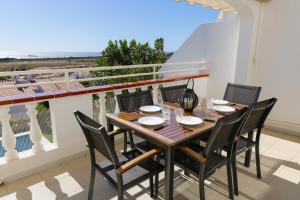ソン・ボウにあるVilla Zodiaco Acuarioの海が見えるバルコニーにテーブルと椅子がある