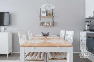 a kitchen with a wooden table and two chairs at Holiday In Lapland - Ylläs Sivulantie 4 214 in Äkäslompolo