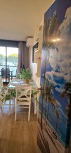 a dining room with a table and palm trees mural at Appartement climatisé avec piscine, magnifique vue mer, lac et le Pic le Canigõ ! in Le Barcarès +71 photos