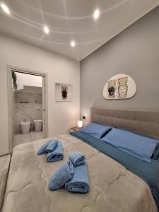 a bedroom with a large bed with towels on it at Casa vacanze al teatro in Catania
