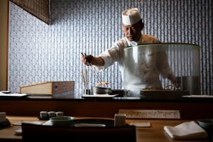 a chef standing in a kitchen preparing food at The Prince Park Tower Tokyo - Preferred Hotels & Resorts, LVX Collection in Tokyo