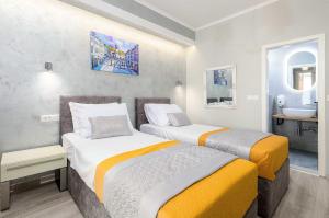 two beds in a small room with a sink at Villa Dubelj Dubrovnik in Mokošica