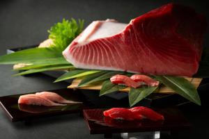a piece of meat sitting on a plate with sushi at The Prince Park Tower Tokyo - Preferred Hotels & Resorts, LVX Collection in Tokyo