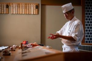 a chef standing in a kitchen preparing food at The Prince Park Tower Tokyo - Preferred Hotels & Resorts, LVX Collection in Tokyo